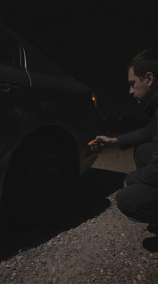 Sentinel keychain light switching on and lighting a flat tire at night